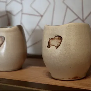 a couple of cups on a shelf