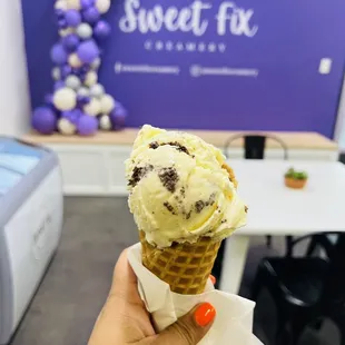 a hand holding an ice cream cone