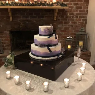 a wedding cake on a table with candles