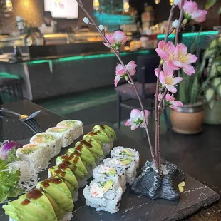 sushi and avocado on a slate platter