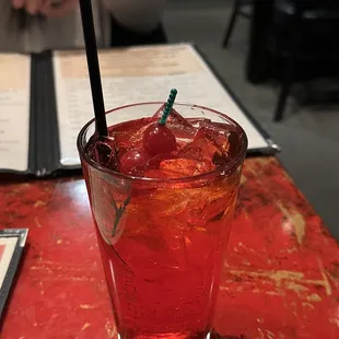 a drink with a straw and a cherry garnish