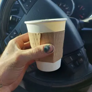 a hand holding a coffee cup