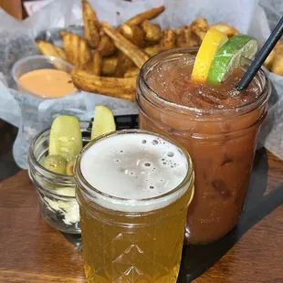 two glasses of beer and a basket of fries