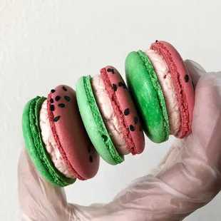 a hand holding a stack of macarons