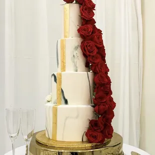 a wedding cake with red roses