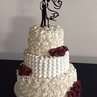 a wedding cake with a bride and groom topper