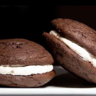 two chocolate macarons with cream filling