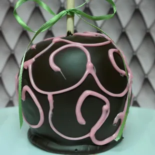 a chocolate covered apple with pink icing