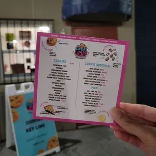 a hand holding a menu