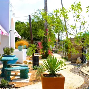 a garden with a bench and potted plants