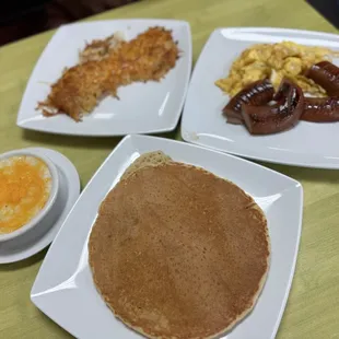 Smoked sausage, scrambled eggs, Grits with cheese, hashbrowns with cheese, and a pancake