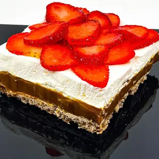 Baked Meringue with a crisp crust and soft light inside , Almonds , Dulce de leche layer top with slice strawberries