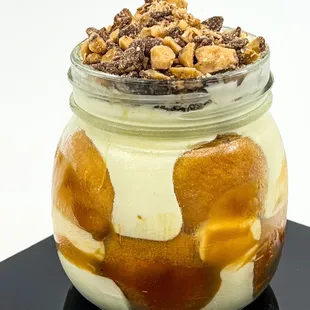 Layers of banana pudding, sliced fresh bananas, vanilla wafers, and topped with a crunchy toffee.