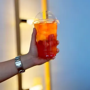 a hand holding a cup of iced tea