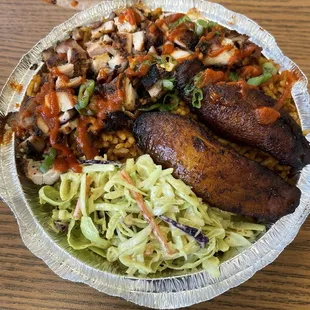 Rice bowl with chicken. The plantains and Cole slaw come standard. The red sauce drizzled on top is the Sweet Mother Sauce.