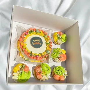 a cake and cupcakes in a box