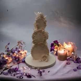 a wedding cake on a table with candles