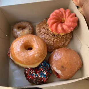 Raspberry filled, blueberry, chocolate sprinkle, pink sprinkle, cinnamon roll, pink french cruller, and plain (complimentary!)
