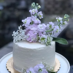 a white cake with purple flowers