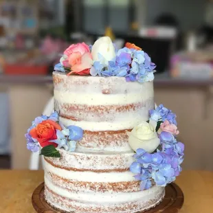 a three tiered cake with flowers on top