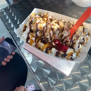 a person taking a picture of a sundae