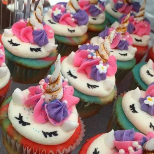 unicorn cupcakes with white frosting and pink and purple icing