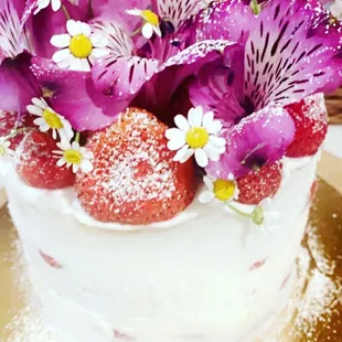 a cake with strawberries and flowers
