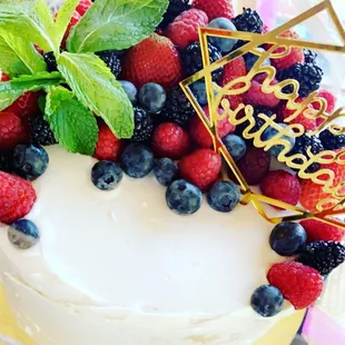 a cake with berries and mint leaves