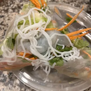 a clear plastic plate with a salad on it