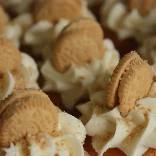 a plate of cupcakes with cream frosting