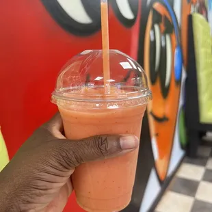 a hand holding a smoothie