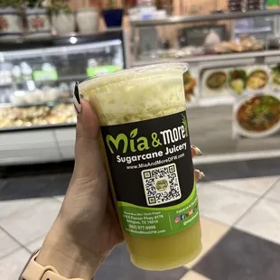 a person holding a cup of juice