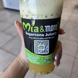 a hand holding a cup of green tea