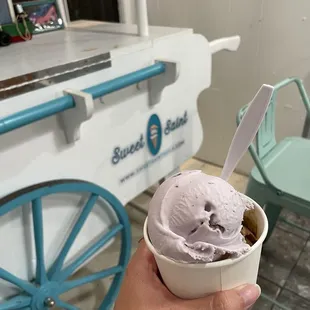 a hand holding a cup of ice cream