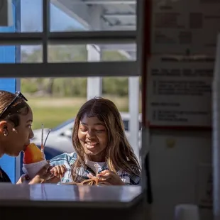 Walk-up window available. Parking in front of stand. Pictured is a strawberry/ pineapple snowball.