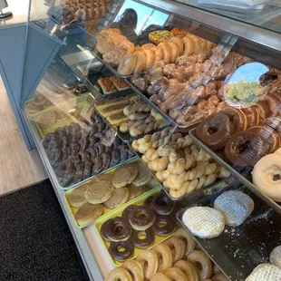 One of the display cases filled with donuts,  they smell wonderful.