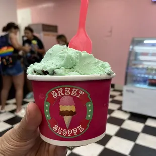 a hand holding a cup of ice cream