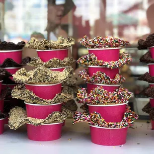 a display of cupcakes with chocolate frosting and sprinkles