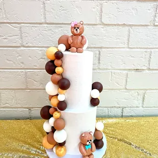 a three tiered cake decorated with teddy bears