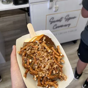 a person holding a container of sweet spoons