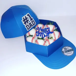 a box of baseballs and a cap