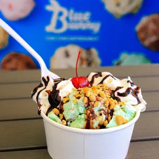 a cup of ice cream with a cherry on top