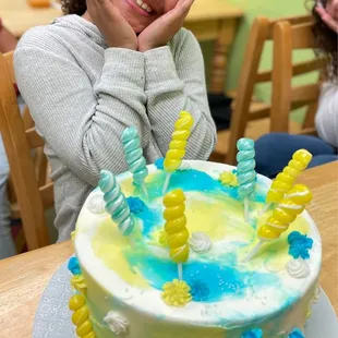 a young girl sitting in front of a birthday cake