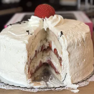 Layers of moist AF white cake, layers of Guittard chocolate frosting, fresh strawberries and whipped cream! GASM!