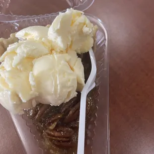 Pecan pie with a kid&apos;s scoop of vanilla ice cream.