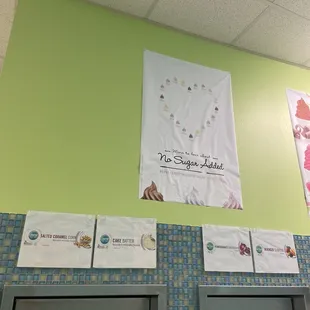 a green wall with a variety of posters on it