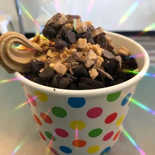 a cup of ice cream with chocolate and candy