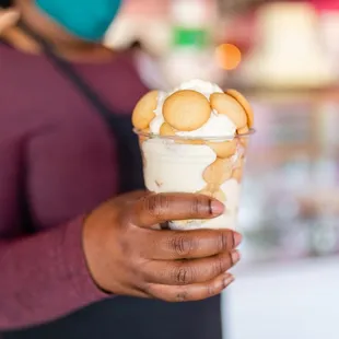  woman holding a cup of dessert