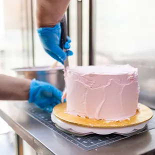  person decorating a cake