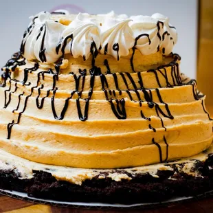 a chocolate cake with whipped cream and chocolate drizzles